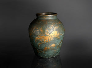 Bronze vase with gold tiger design on a dark background
