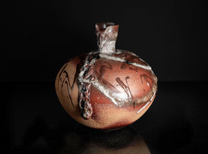 Decorative ceramic pot with intricate designs on a dark background