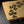 Load image into Gallery viewer, A rectangular ceramic serving tray with a light beige painted surface, decorated with black leaf motifs and small red berry accents, shown on a dark studio background.
