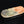 Load image into Gallery viewer, A rustic, hand-carved stone dish with a natural organic shape, featuring a mottled pattern of orange, green, and gray, displayed on a reflective black surface against a black background.
