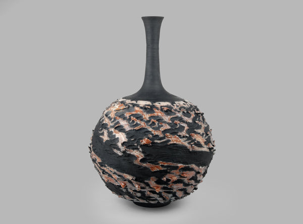 Black vase with textured surface on a gray background