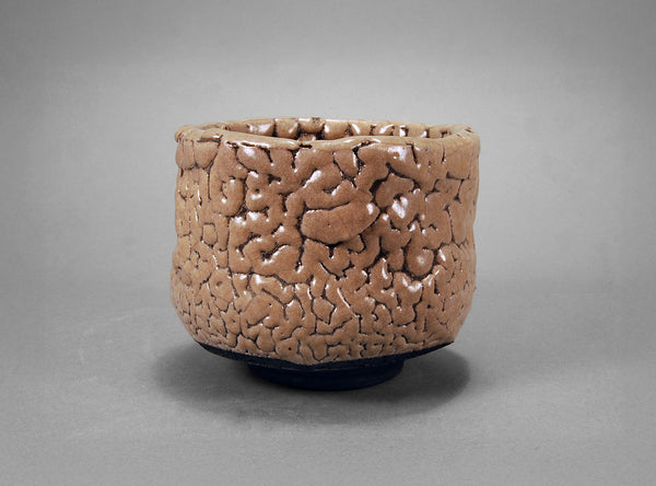 Brown textured ceramic bowl on a gray background