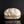 Load image into Gallery viewer, A handmade ceramic lidded box with a textured, organic-shaped cream and brown glazed top and a rustic dark brown base, displayed on a reflective black surface against a black background.
