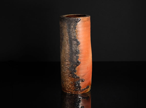 Cylindrical  vase with a textured surface on a black background