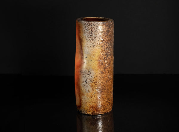 Cylindrical  vase with a textured surface on a black background