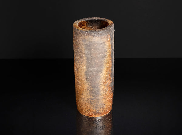 Cylindrical  vase with a textured surface on a black background