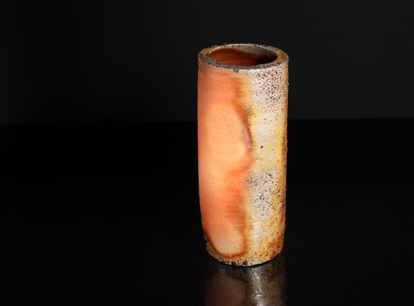 Cylindrical  vase with a textured surface on a black background