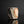 Load image into Gallery viewer, A handmade ceramic guinomi with a textured, geometric design in earthy brown, beige, and white glazes, set against a dark reflective background.

