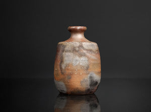Small ceramic bottle with a textured surface on a black background