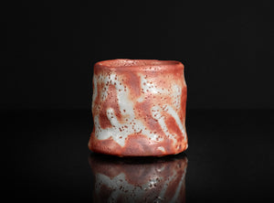 Red and white ceramic cup on a black background