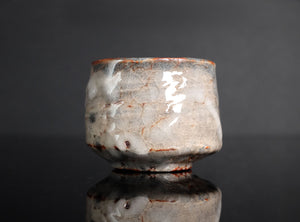 Ceramic cup with a textured surface on a reflective black surface