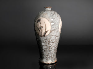 A ceramic vase with a pear-shaped body, featuring a textured gray and white glaze with brown speckles and hand-painted floral motifs on the sides, set against a dark gray background.