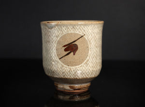 Ceramic cup with decorative patterns on a dark background
