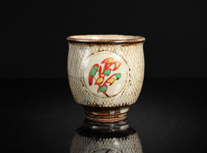 Ceramic cup with decorative design on a black background
