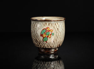 Ceramic cup with decorative design on a black background