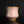 Load image into Gallery viewer, A pink ceramic tea cup with a white hand-painted herringbone pattern and a metallic gold-brown rim, set against a dark reflective background.
