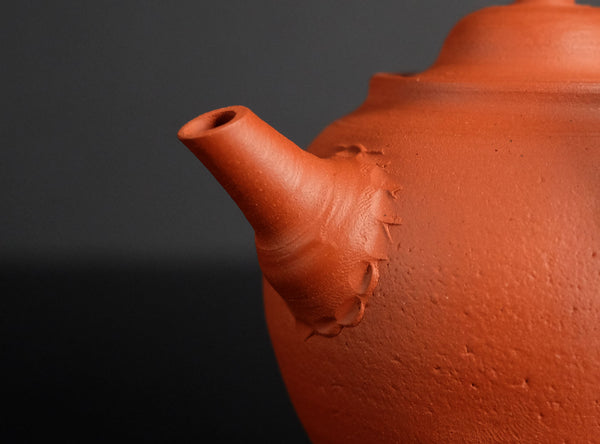 Close-up of a terracotta teapot with a dark background