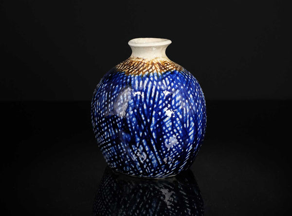 Decorative vase with blue and white pattern on a black background