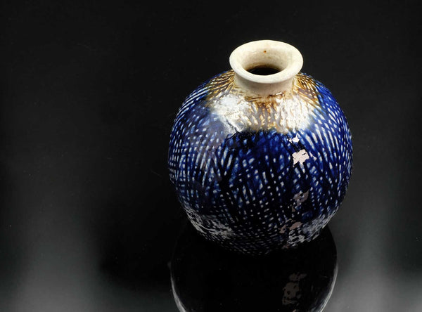 Blue and white ceramic vase on a black background
