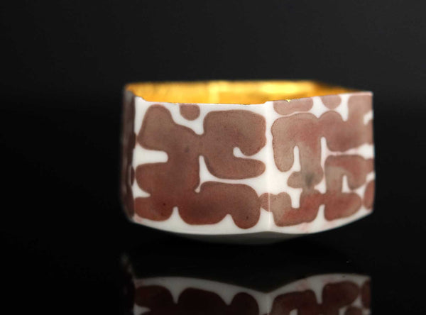 A Gilt Decorated Guinomi with a geometric pattern on a black background