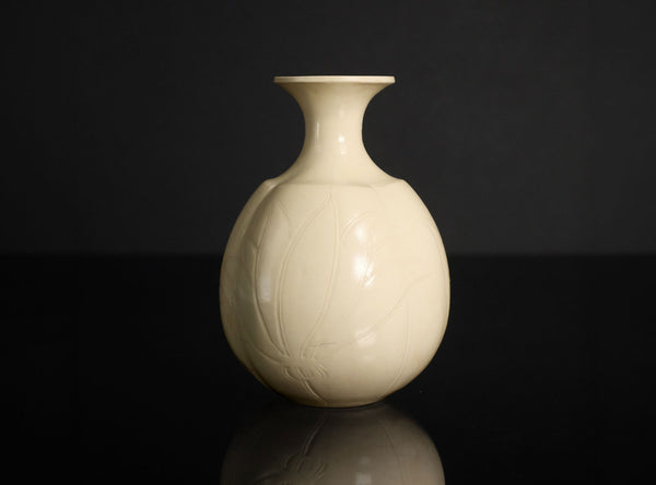 White ceramic sake bottle on a black background