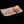 Load image into Gallery viewer, A rectangular ceramic plate with a textured, speckled glaze in gray, orange, and black, featuring a glossy glazed section on one end, set against a solid black background.
