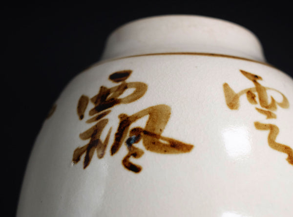 White ceramic container with brown text on a black background