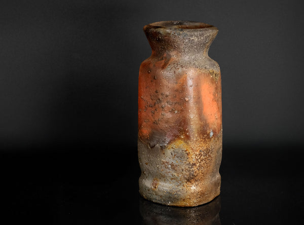 ceramicvase with a textured surface on a black background