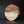 將圖片載入到圖庫檢視器中， A round, textured stone or ceramic sculpture with a gradient of orange, brown, and cream, standing on a dark surface against a black background.
