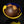 Load image into Gallery viewer, Brown fruit in a yellow bowl with a blue rim on a black background
