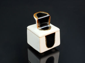 White cube-shaped object with a black interior on a black background