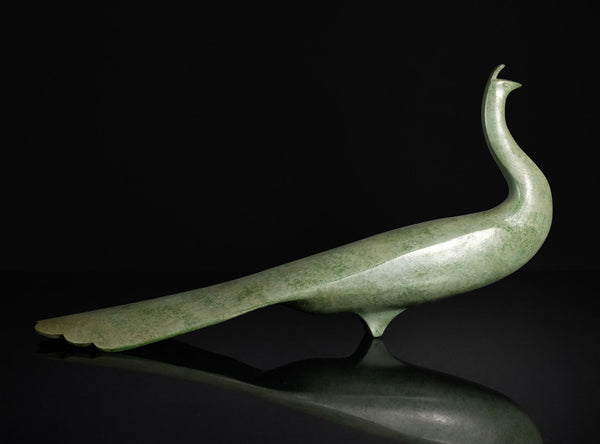 Green jade peacock sculpture on a reflective surface with a black background