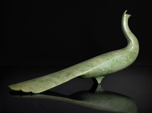 Green jade peacock sculpture on a reflective surface with a black 