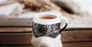 Woman has a cup of black tea in hand